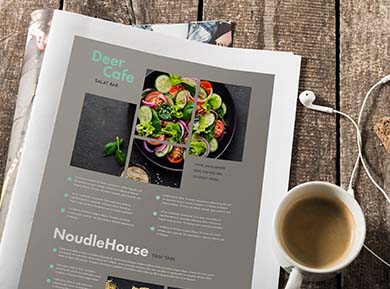 Eine aufgeschlagene Zeitschrift über Restaurants liegt auf dem Tisch, daneben Kaffee und ein Headset