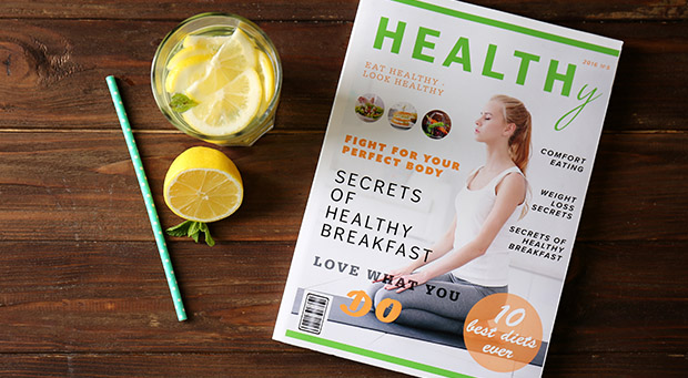 ein gedrucktes Magazin über Gesundheit liegt auf dem Tisch; dazu gibt es ein Getränk mit frischer Zitrone